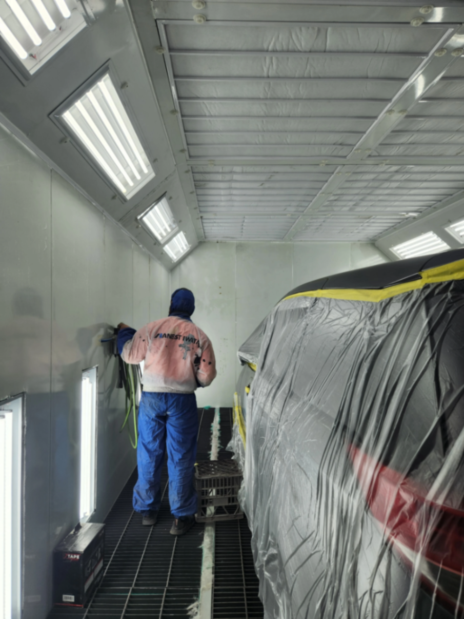 Autopro technician prepping a panel inside the spray booth