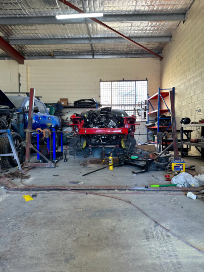 Wide view of the Autopro workshop with a vehicle on the chassis rack