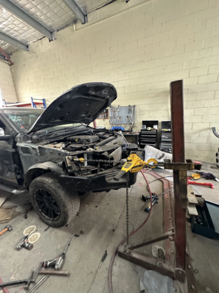 Car body frame being aligned in a panel beating workshop